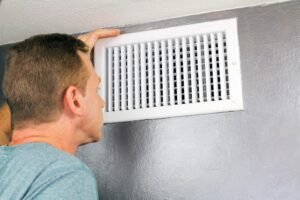 Man Checking Air Vent for good airflow